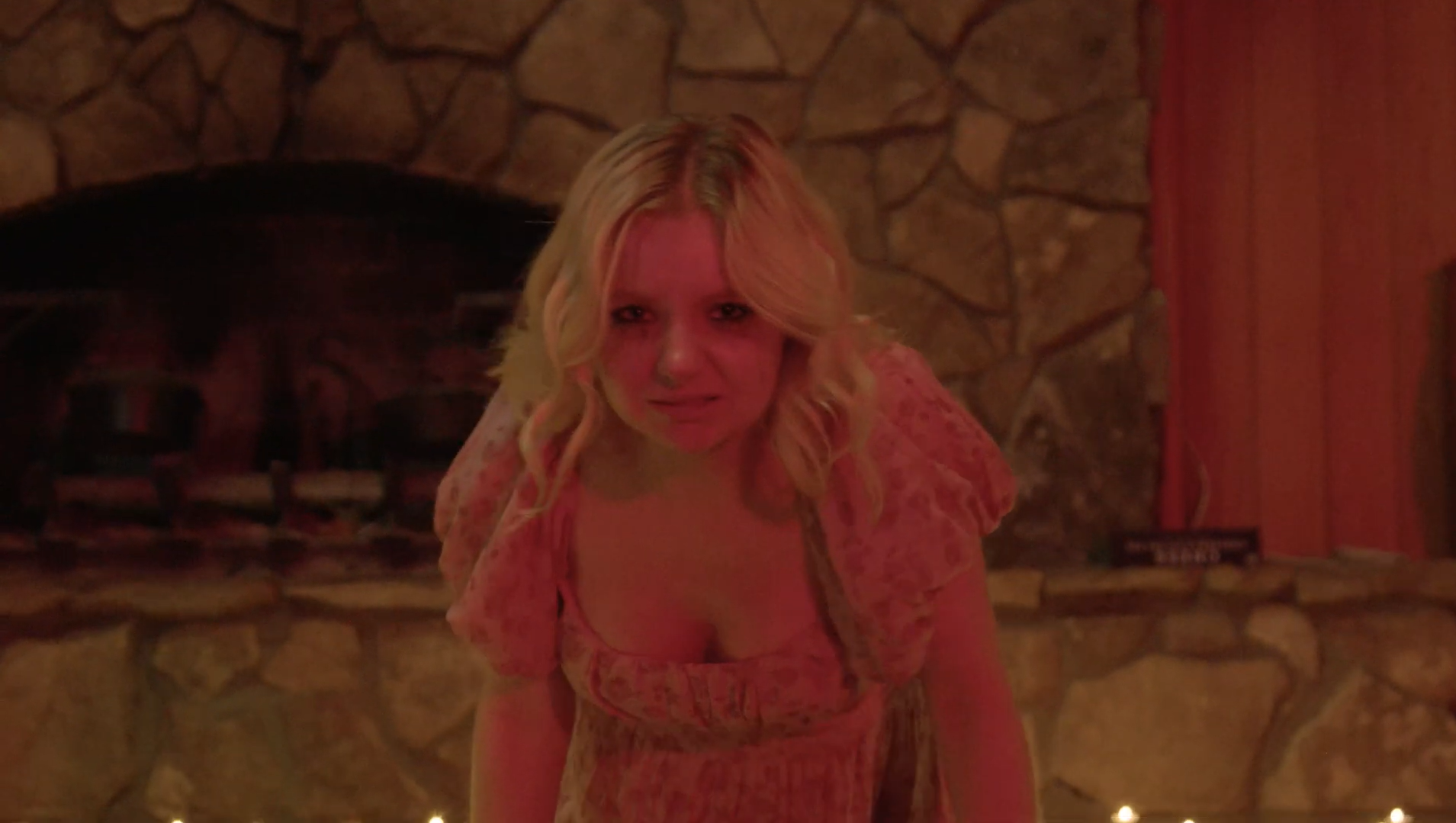 A shot from POWEROUTAGE. A woman crawls derranged in red lighting.